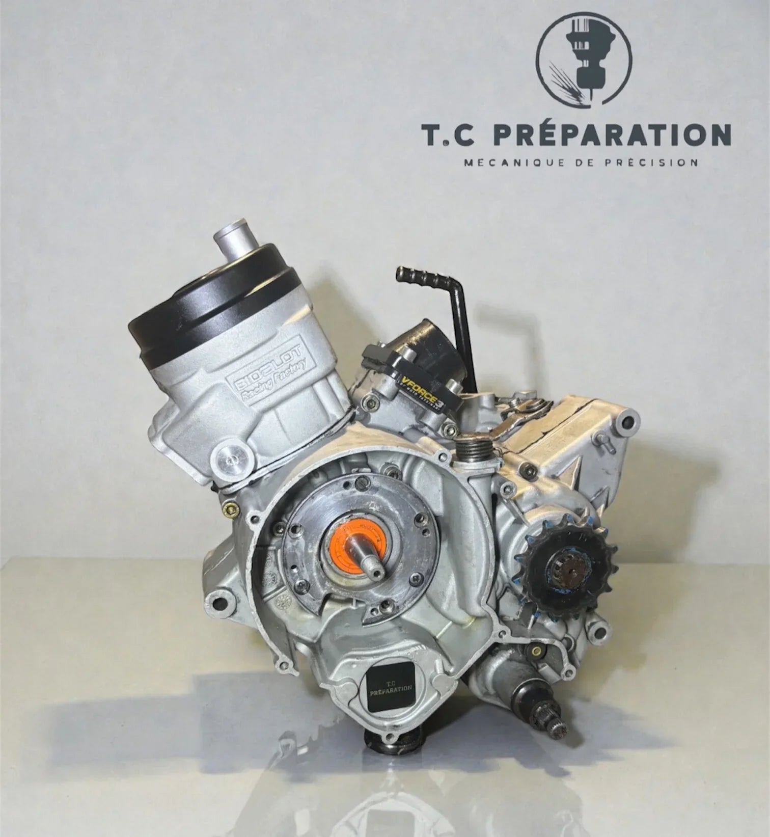 Bloc moteur de moto deux-temps posé sur fond clair, pièce mécanique prête à l'installation